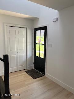 doorway to outside with baseboards and light wood-type flooring
