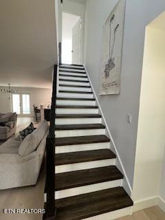 staircase with baseboards and wood finished floors