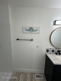 bathroom featuring visible vents, wood finished floors, and vanity