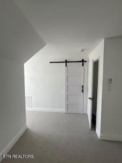 hallway with baseboards and a barn door