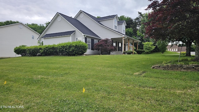 exterior space with a shingled roof and a front yard