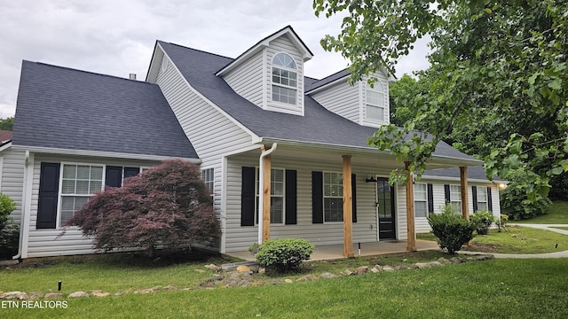 view of side of property featuring a porch and a lawn