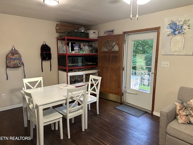 dining space with baseboards and dark wood-type flooring