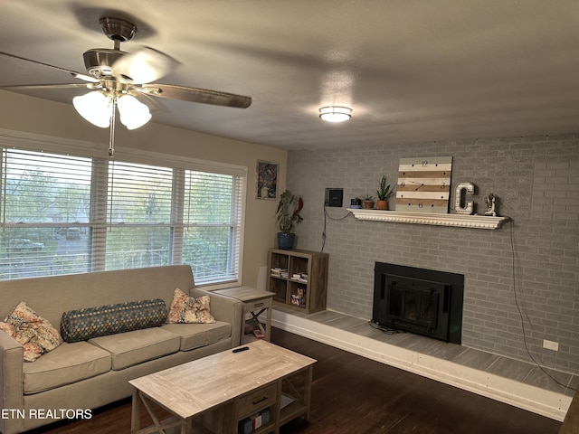 living room featuring a brick fireplace, a ceiling fan, and wood finished floors