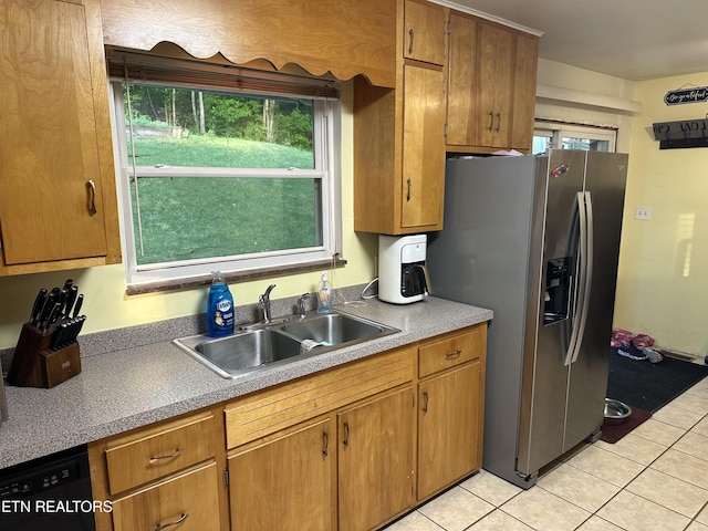 kitchen with a sink, dishwasher, plenty of natural light, light tile patterned floors, and stainless steel refrigerator with ice dispenser