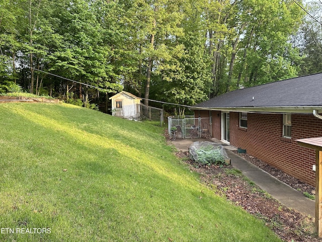 view of yard with fence, a storage unit, and an outdoor structure
