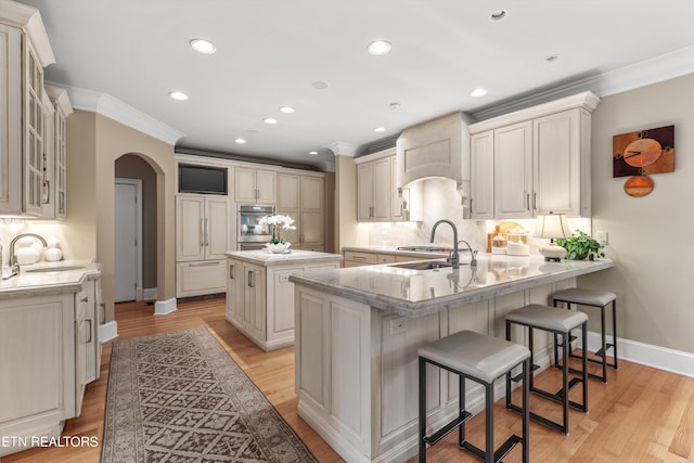 5315 Bent River Blvd, Knoxville, TN 37919 - kitchen featuring a sink, arched walkways, a peninsula, oven, and crown molding
