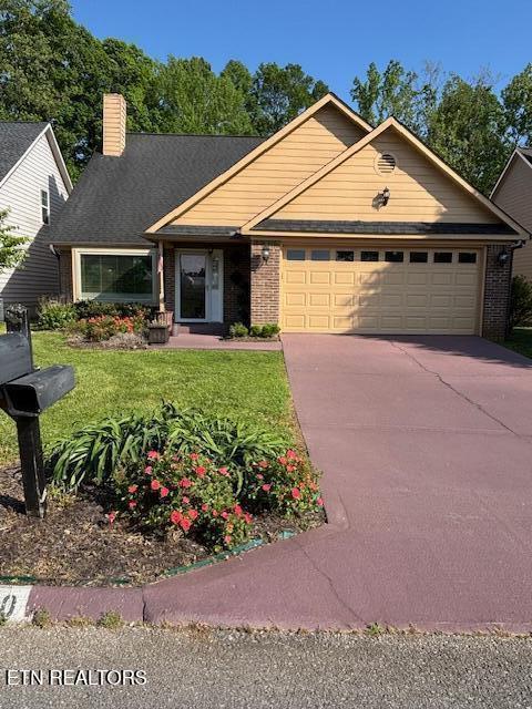 ranch-style home with an attached garage, a front lawn, brick siding, a chimney, and driveway