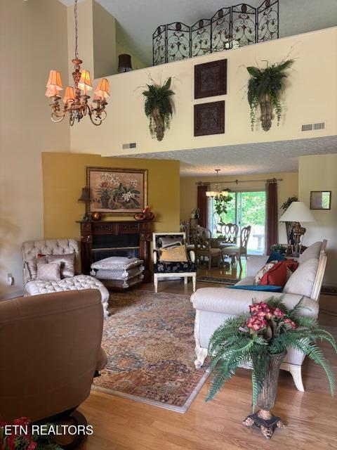 living room featuring visible vents, a high ceiling, and a chandelier