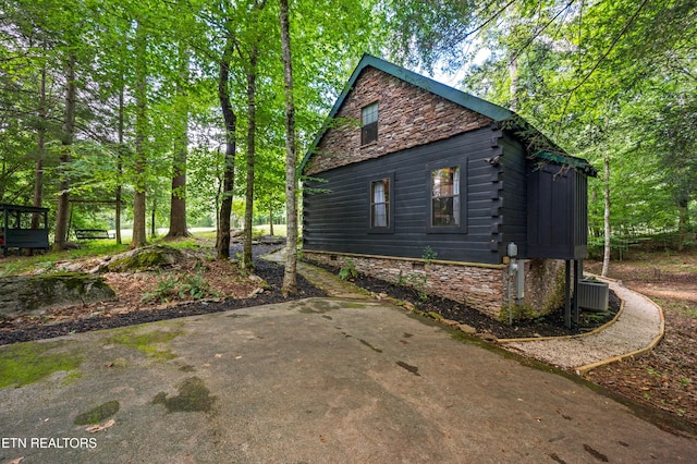 view of side of home featuring stone siding and log exterior