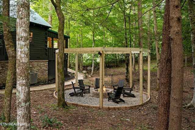 view of yard with central AC unit, a patio, and a fire pit
