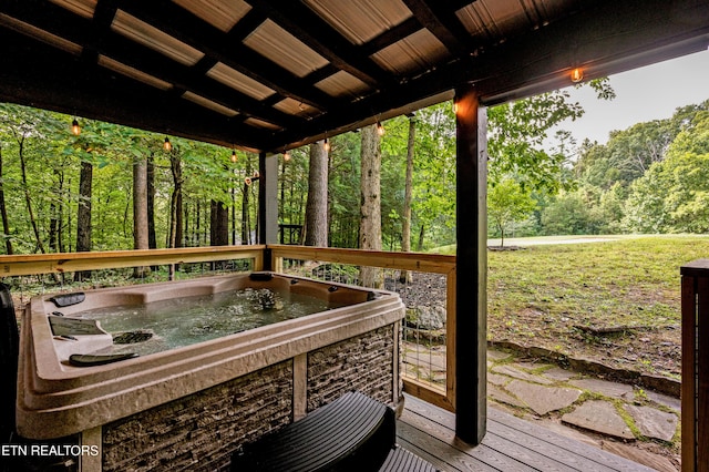 wooden deck with a forest view and a hot tub