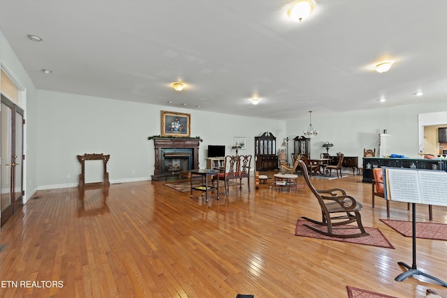 702 Meadowview Dr, Harriman, TN 37748 - interior space featuring baseboards, a fireplace with raised hearth, hardwood / wood-style flooring, and an inviting chandelier