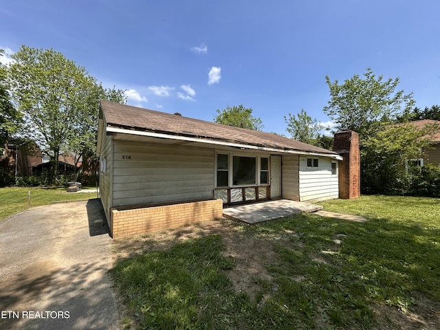 rear view of property featuring a patio area and a yard