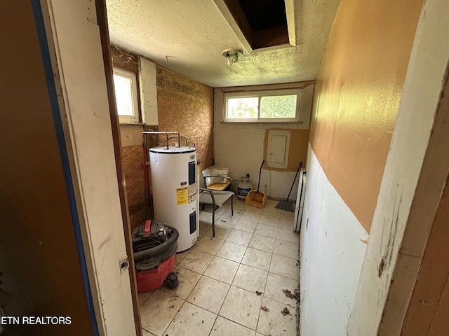 bathroom featuring tile patterned floors, a wealth of natural light, a textured ceiling, and electric water heater