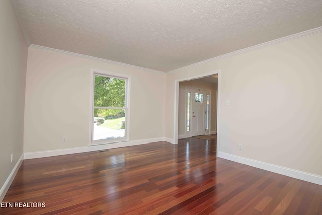 spare room featuring baseboards, a textured ceiling, a wealth of natural light, and hardwood / wood-style floors
