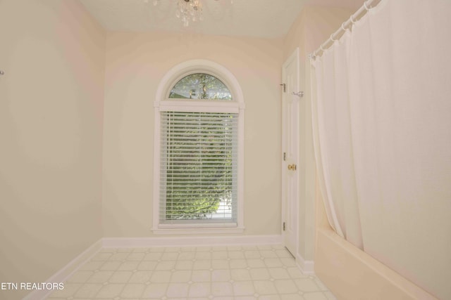unfurnished room with light floors and baseboards