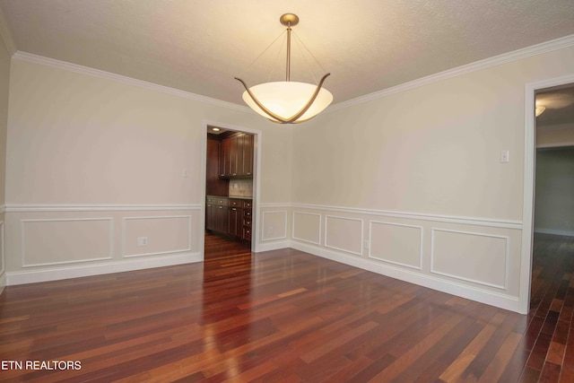 unfurnished room with a wainscoted wall, a decorative wall, and dark wood-style flooring