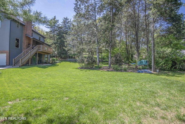 view of yard featuring a wooden deck and stairs