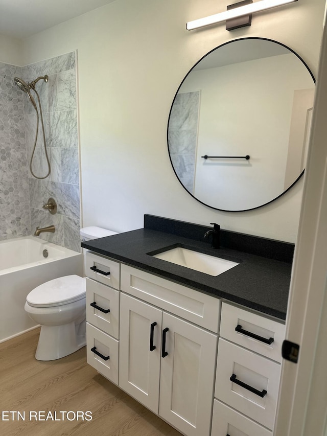 full bath with toilet, vanity, bathtub / shower combination, and wood finished floors