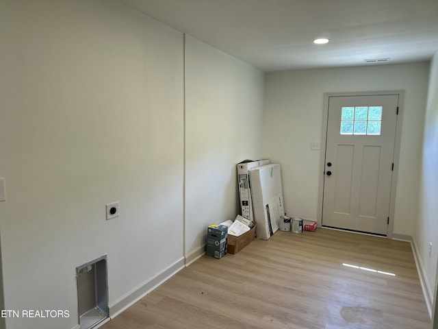 doorway featuring light wood finished floors, visible vents, baseboards, and recessed lighting
