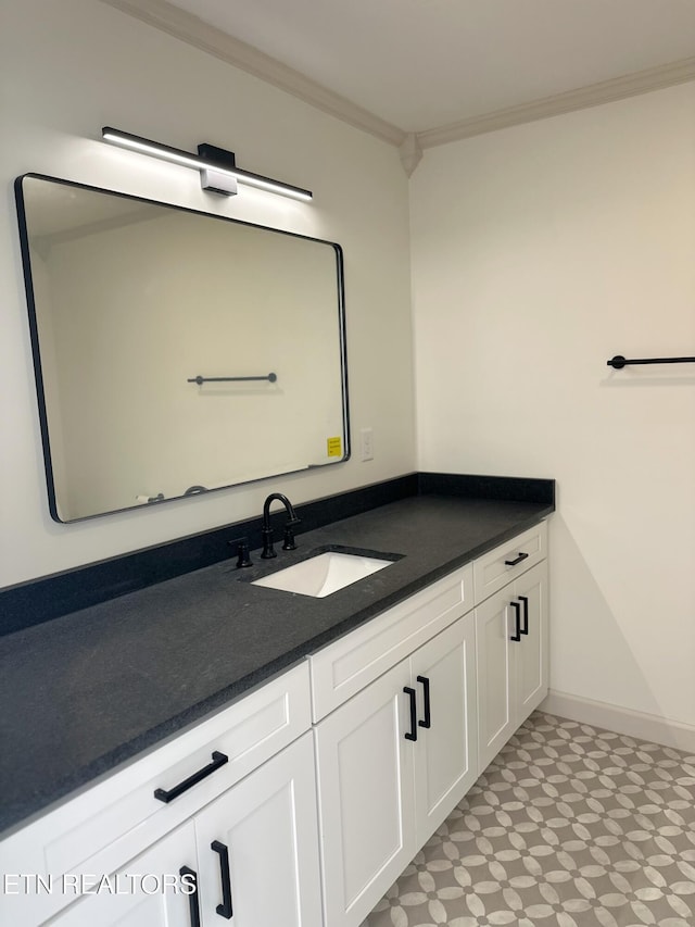 bathroom featuring crown molding, baseboards, and vanity