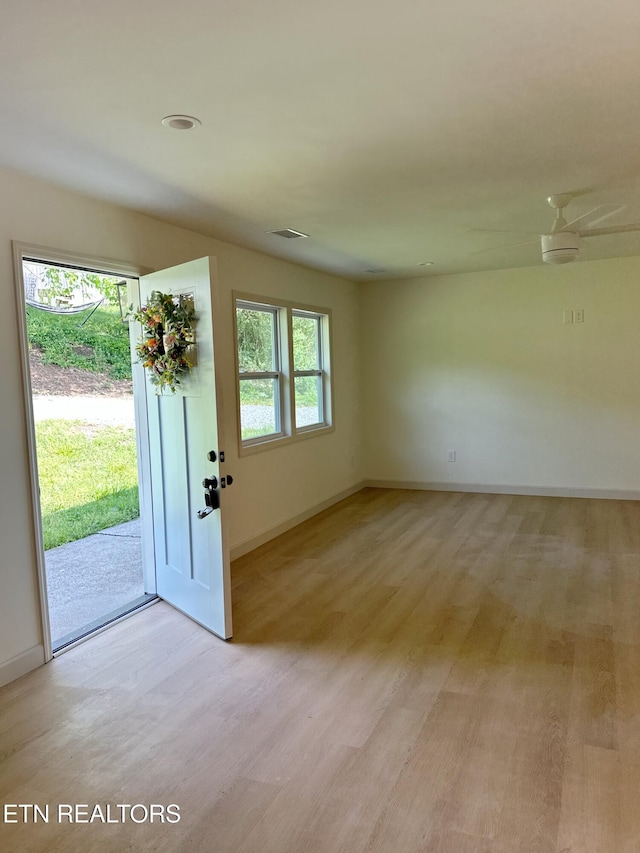 foyer with light wood-style floors, visible vents, and baseboards