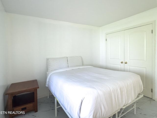 bedroom featuring a closet and marble finish floor