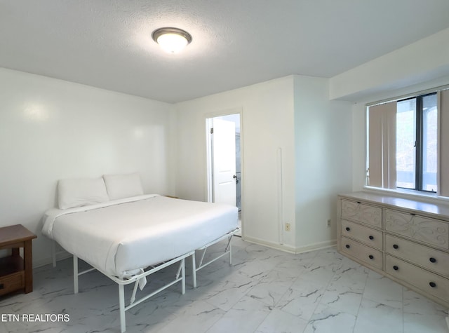 bedroom with marble finish floor, baseboards, and a textured ceiling