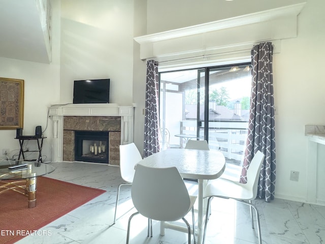 dining space featuring a high end fireplace and marble finish floor