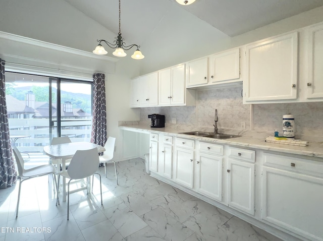 kitchen with marble finish floor, a sink, white cabinetry, high vaulted ceiling, and decorative backsplash