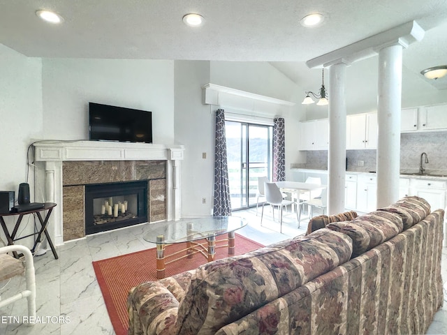 living area featuring a premium fireplace, lofted ceiling, marble finish floor, and recessed lighting