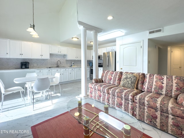 living room featuring ornate columns, marble finish floor, and visible vents