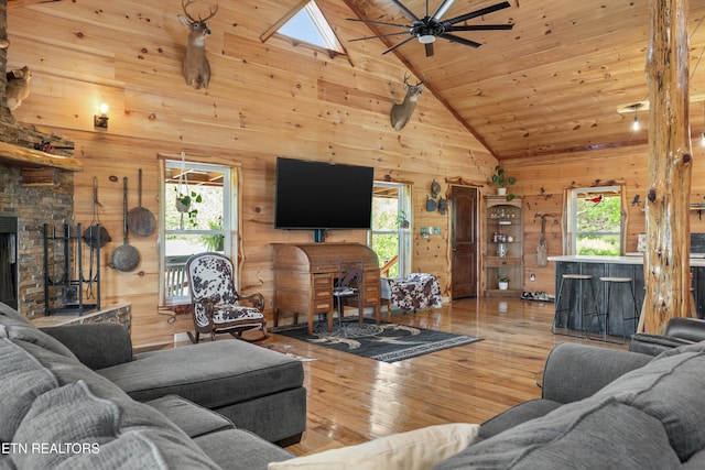 487 Fish Hatchery Rd, Sweetwater, TN 37874 - living room featuring wood walls, wood-type flooring, a ceiling fan, high vaulted ceiling, and a skylight