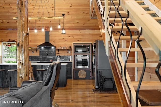 487 Fish Hatchery Rd, Sweetwater, TN 37874 - kitchen featuring appliances with stainless steel finishes, island exhaust hood, wood finished floors, wood walls, and light countertops