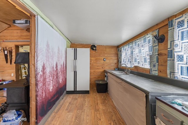 487 Fish Hatchery Rd, Sweetwater, TN 37874 - kitchen featuring a sink, freestanding refrigerator, wood walls, light wood-style floors, and dark countertops