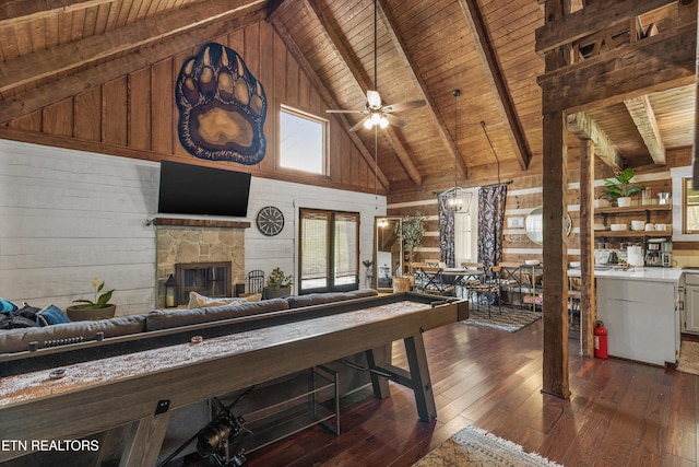 living area with wooden walls, wood ceiling, plenty of natural light, and high vaulted ceiling