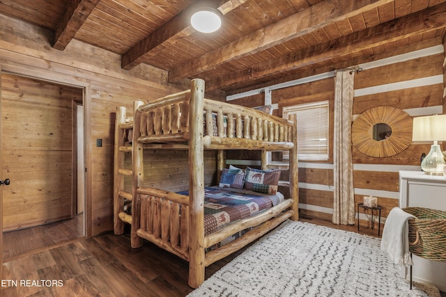 bedroom with beamed ceiling, wood walls, wooden ceiling, and wood finished floors