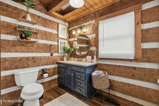 bathroom with vanity, wood finished floors, toilet, wooden walls, and wood ceiling