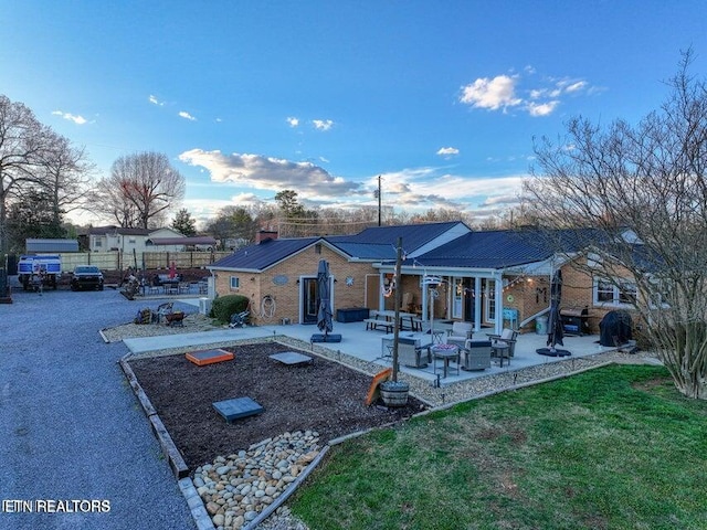 view of front of house featuring a patio, an outdoor living space, fence, and a front yard