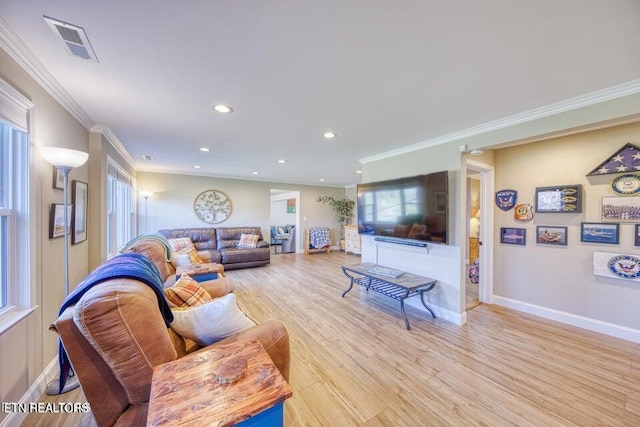living area featuring visible vents, baseboards, ornamental molding, recessed lighting, and light wood-style flooring