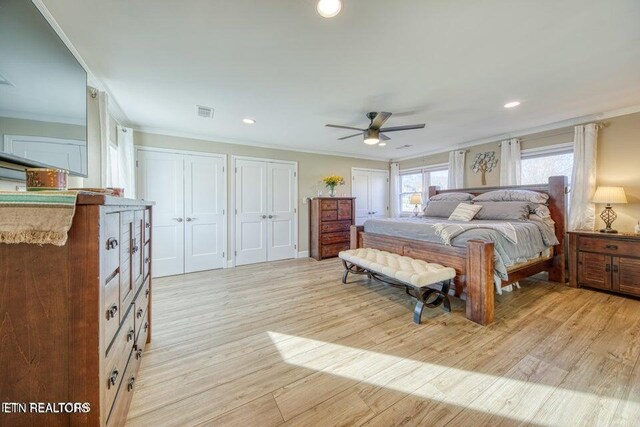 bedroom featuring visible vents, ornamental molding, multiple closets, light wood-style floors, and recessed lighting