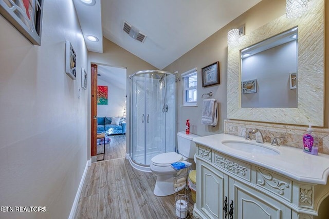 full bathroom featuring visible vents, vaulted ceiling, wood finished floors, vanity, and toilet