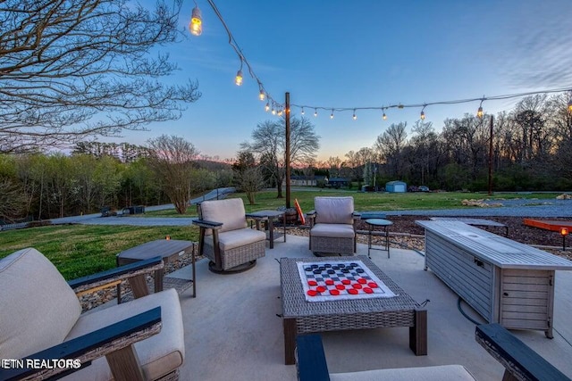 patio terrace at dusk featuring a lawn