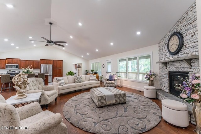 living area with recessed lighting, a fireplace, wood finished floors, and high vaulted ceiling