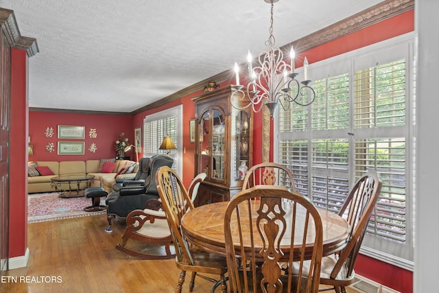 145 Lynn Ave, Jellico, TN 37762 - dining area with crown molding, wood finished floors, a textured ceiling, and a notable chandelier