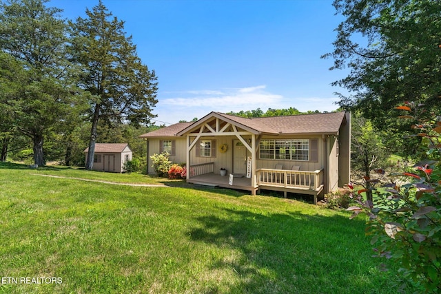 rear view of house featuring a lawn, board and batten siding, a shed, and an outbuilding