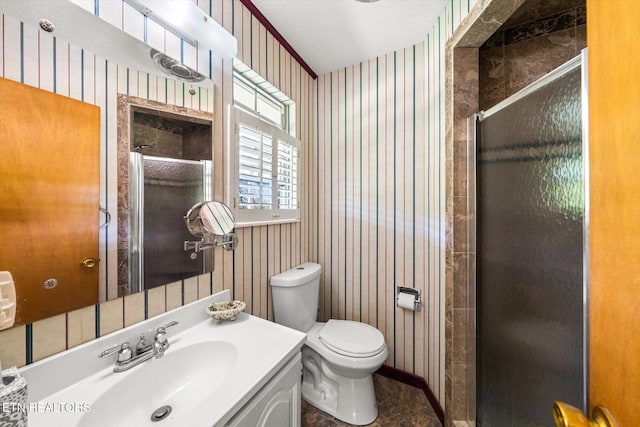 bathroom with a shower stall, vanity, baseboards, toilet, and wallpapered walls