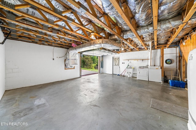 garage featuring independent washer and dryer and concrete block wall