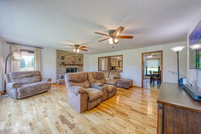 living room with ceiling fan, light wood-style flooring, and a fireplace